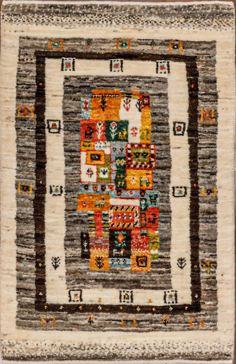 Rustic tribal Gabbeh handmade carpet measuring 2x3 and featuring a design of borders in natural wool tons and central field of brighter colors. 