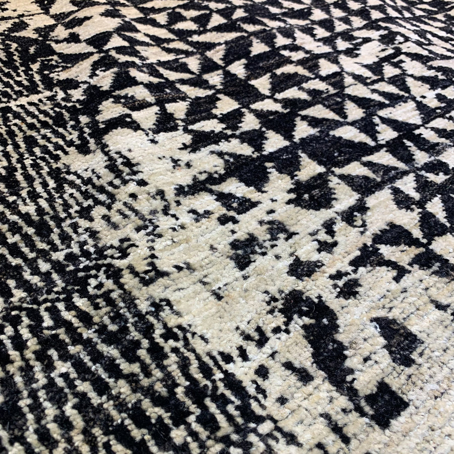 Detail of Pattern Mix 5 from Battilossi Rugs. Handwoven 8x10 wool rug in light beige and black pattern of triangles.