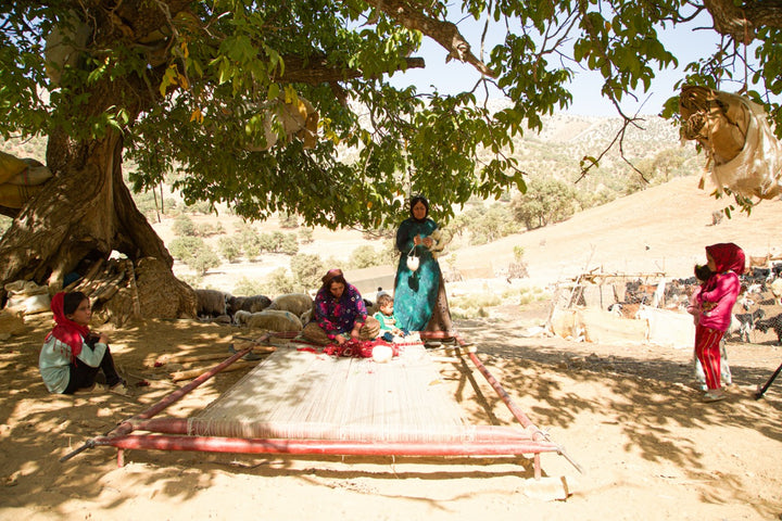 Semi-Nomadic Weavers in Southern Iran producing a Gabbeh Persian Rug on a traditional horizontal loom.