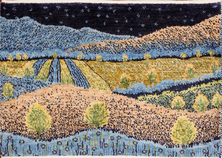 This 3x2 small gabbeh rug shows a night scene of fields, hills, and trees in blue, various green tones, and yellow ivory all hand-knotted in wool. 