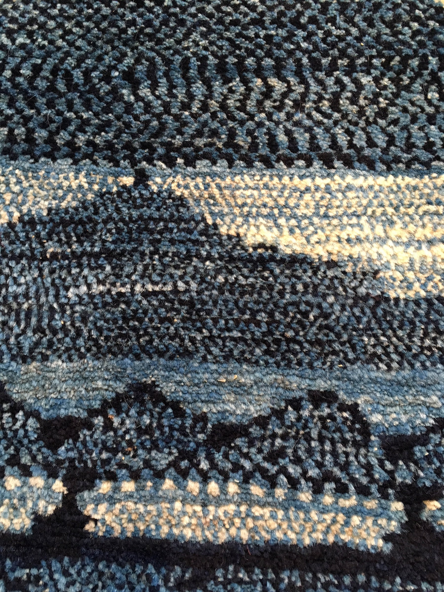 Close up detail showing the precise knotting and subtle tones of indigo. 