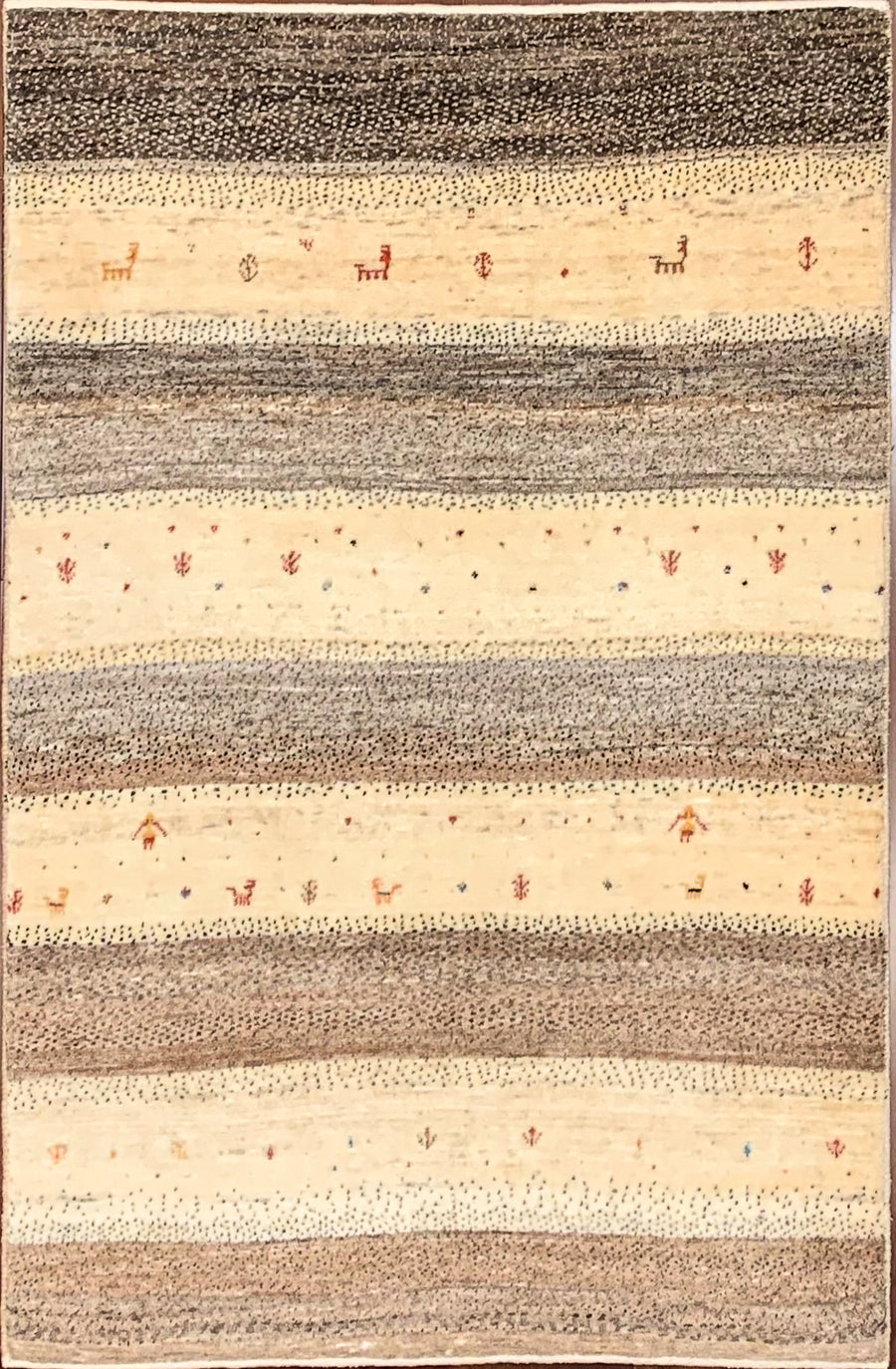 Undyed Persian Tribal Gabbeh with small plant symbols, small human figures, and deer in reds and oranges.