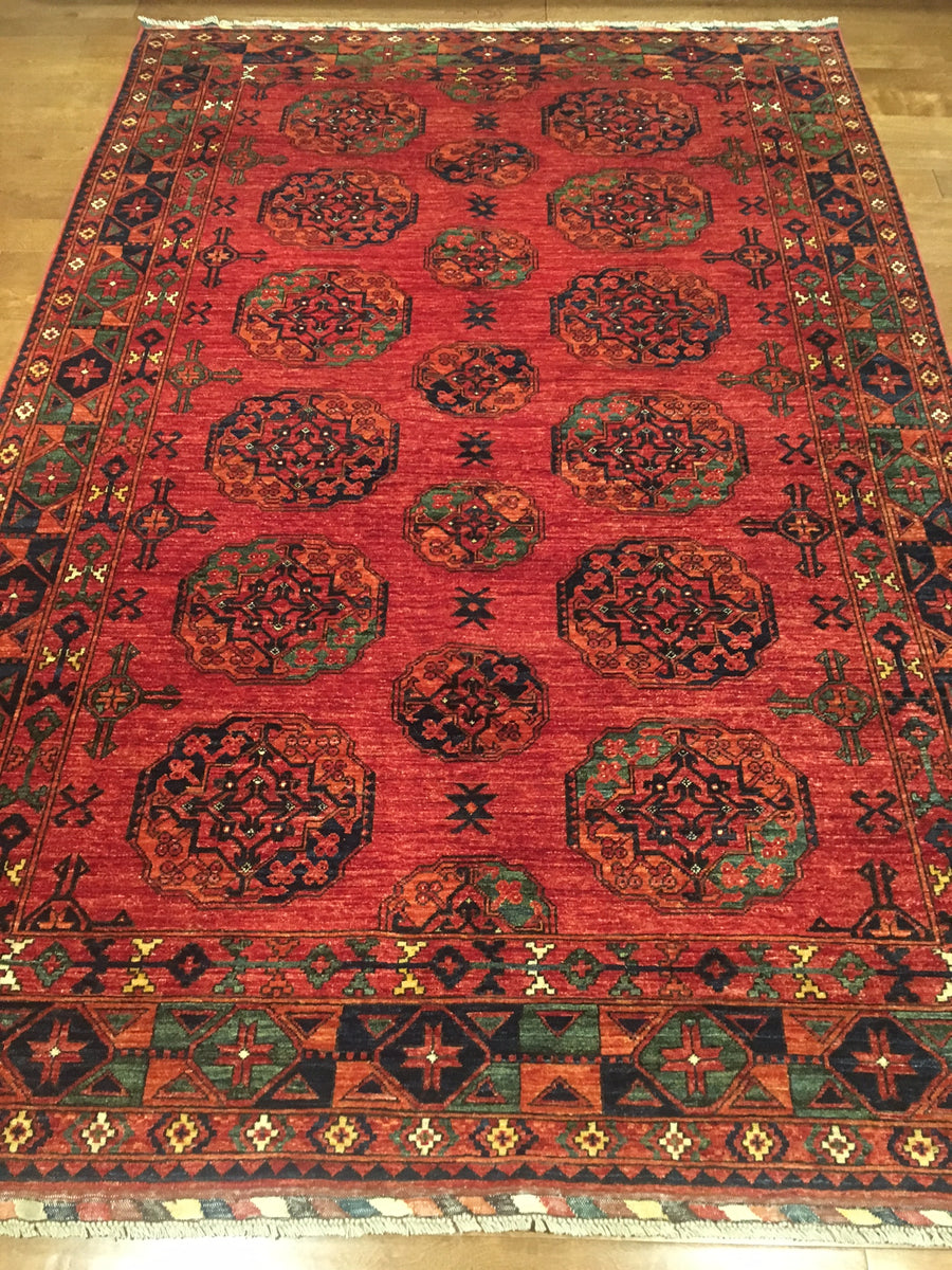 Classic Afghan pattern Tekke rug in reds, greens, and dark navy blues. 