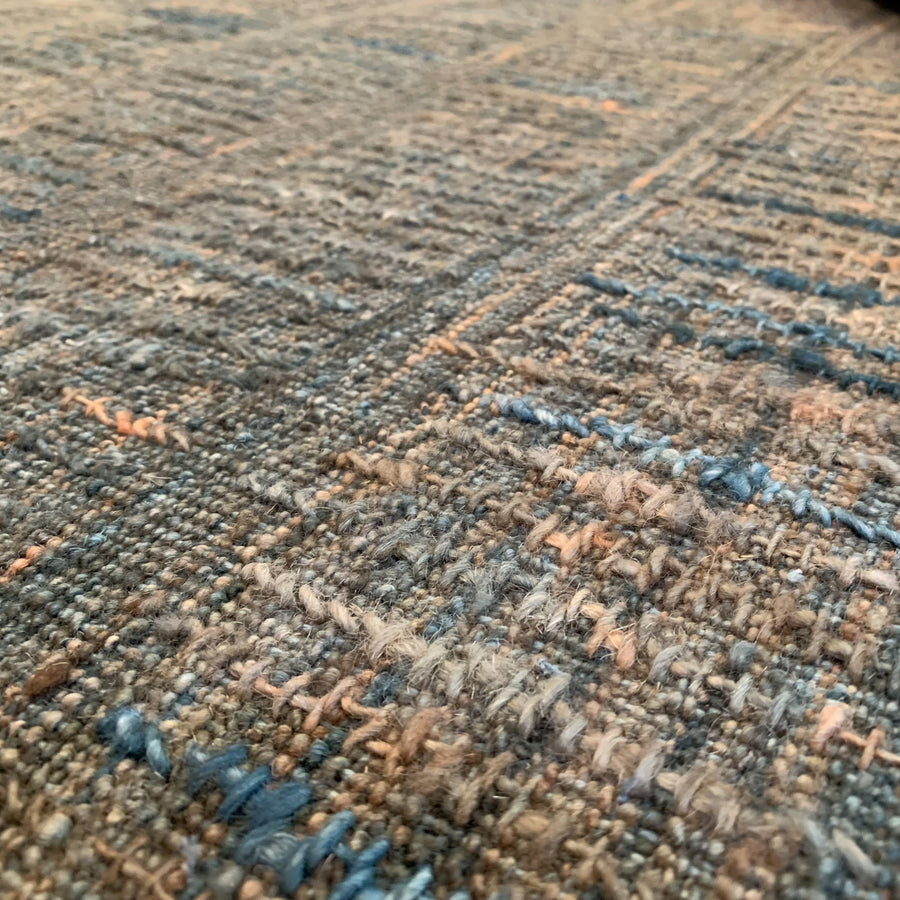 Close-up detail of the Storm in Cactus from the Avita Collection by Battilossi Rugs. This 6x9 hand-knotted rug features sea green, green, beige, and tan colors in 100% ghanzi wool