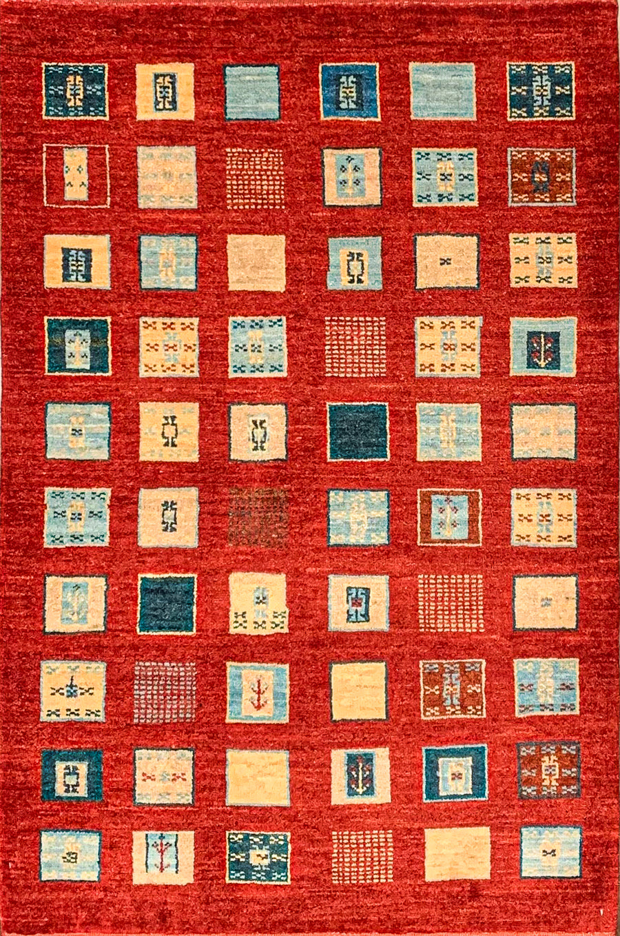 Rustic Tribal Gabbeh Throw Rug With Several Squares of Various Colors and Designs on a Field of Red Wool.